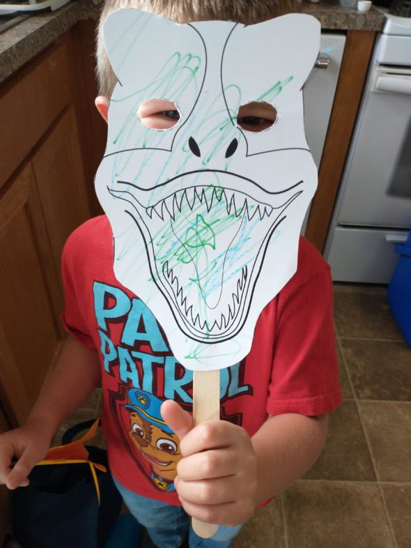 Ruth's son holding up a paper mask.