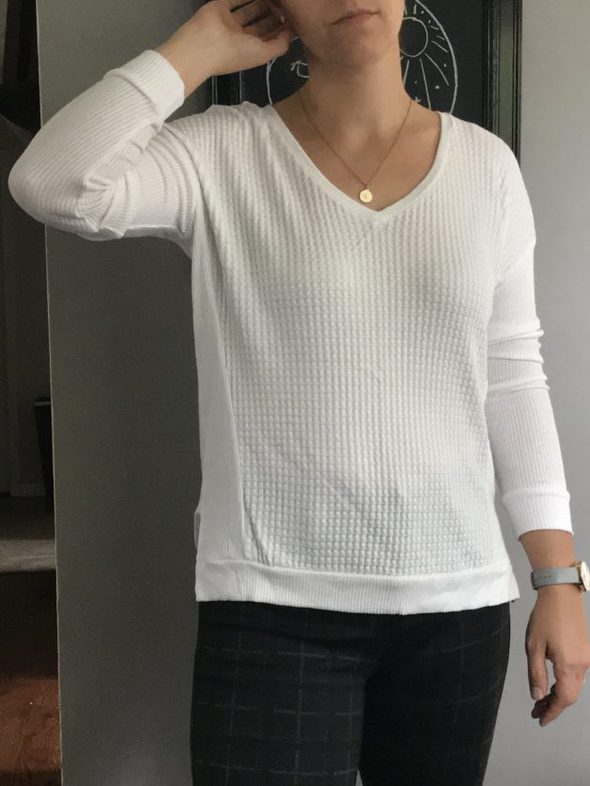 Kristen wearing a white v-neck shirt.