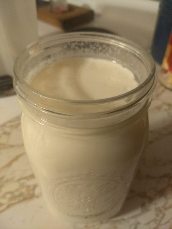 Glass Mason jar of homemade yogurt.