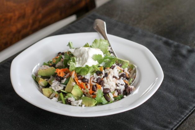 Burrito bowl leftovers in white bowl.