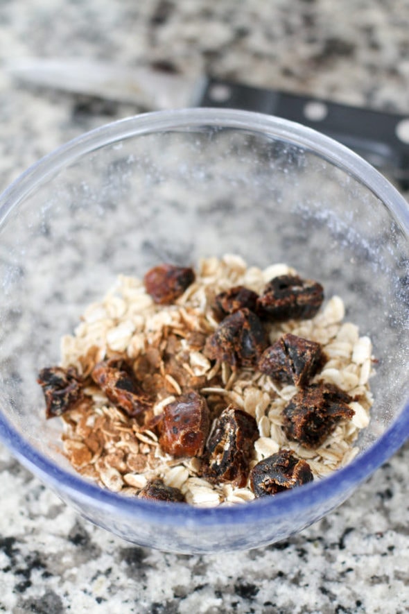 Dates in a bowl of uncooked oats