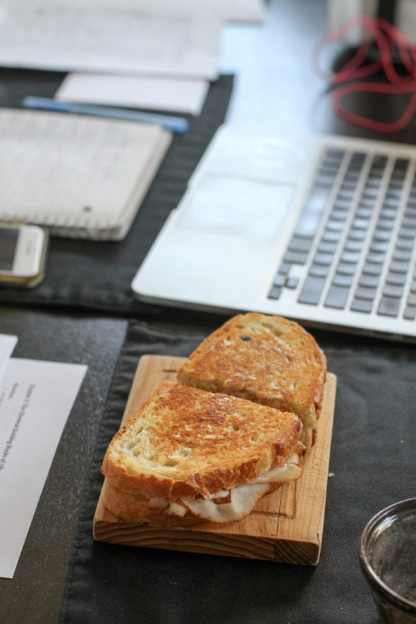 Panini on a plate next to a laptop.