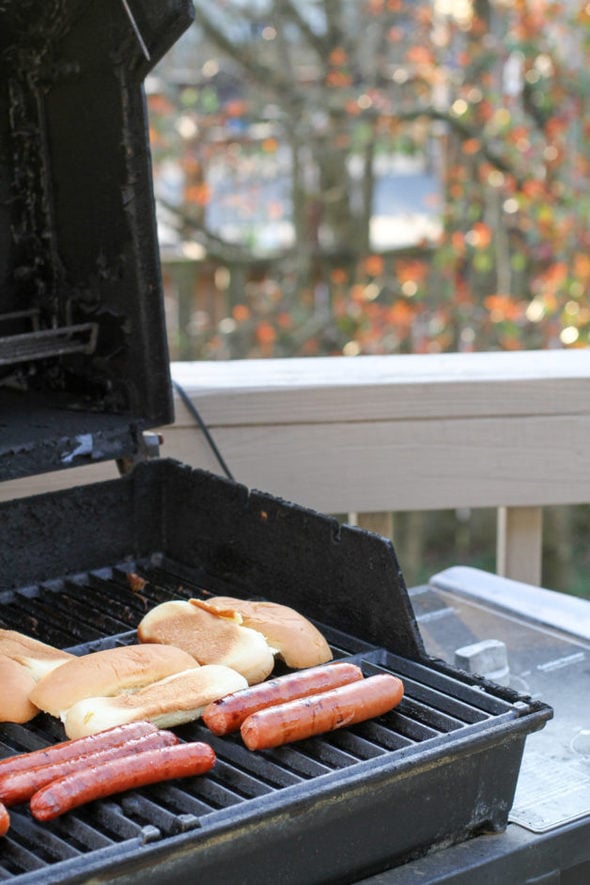 Bratwurst on the grill with buns.