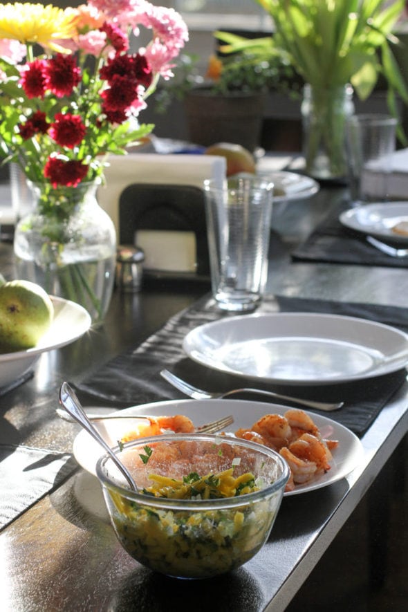 Dining room table with plates and mango salsa.