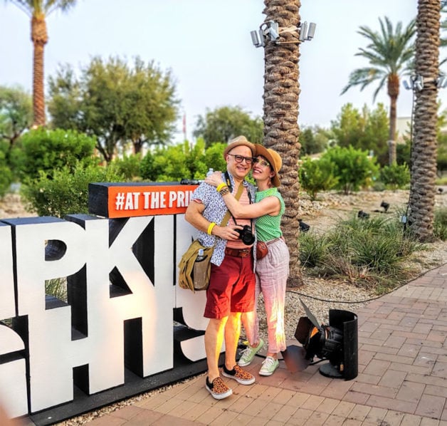 Jodie hugging her husband, with palm trees in the background.