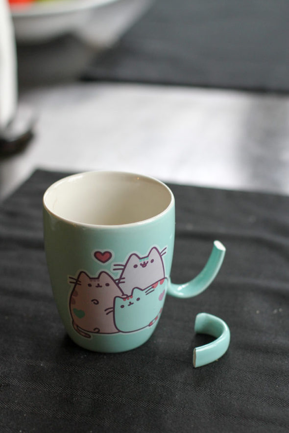 Green Pusheen mug with a broken handle.