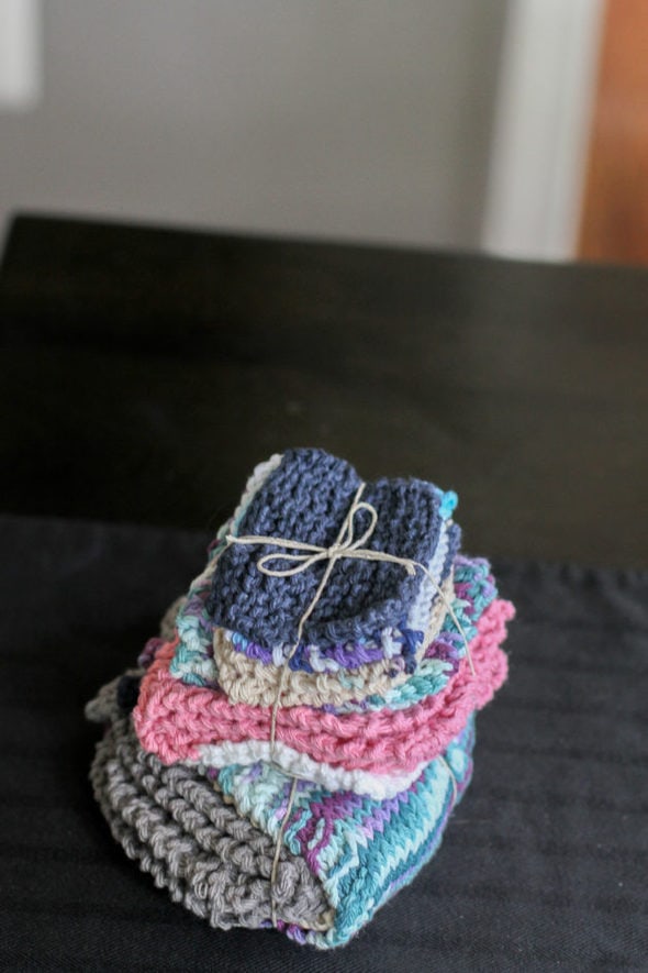 A stack of hand-knitted dishcloths, tied with a string.