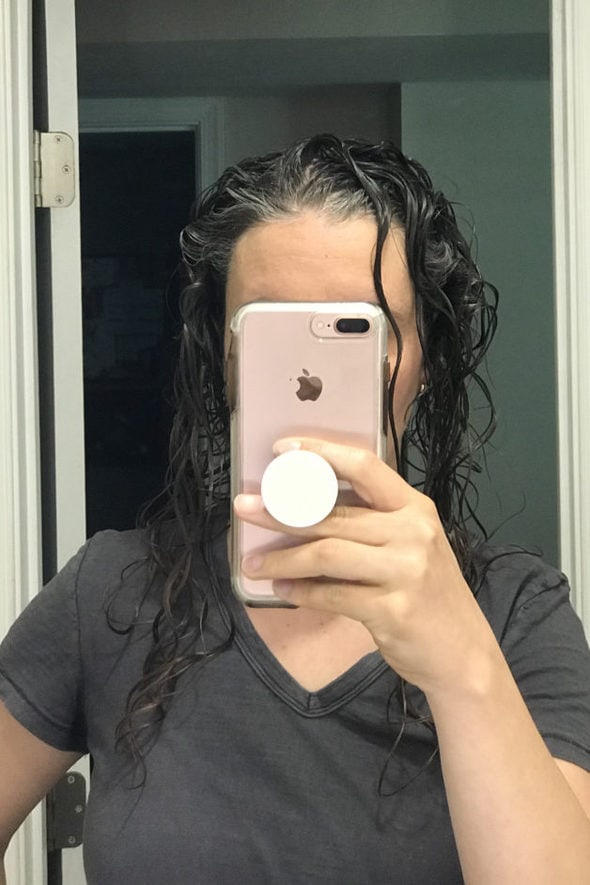 Kristen with wet, gelled hair, taking a mirror selfie.