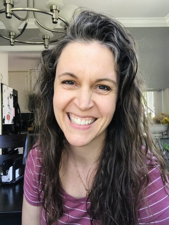 Kristen with wavy hair, smiling at the camera.