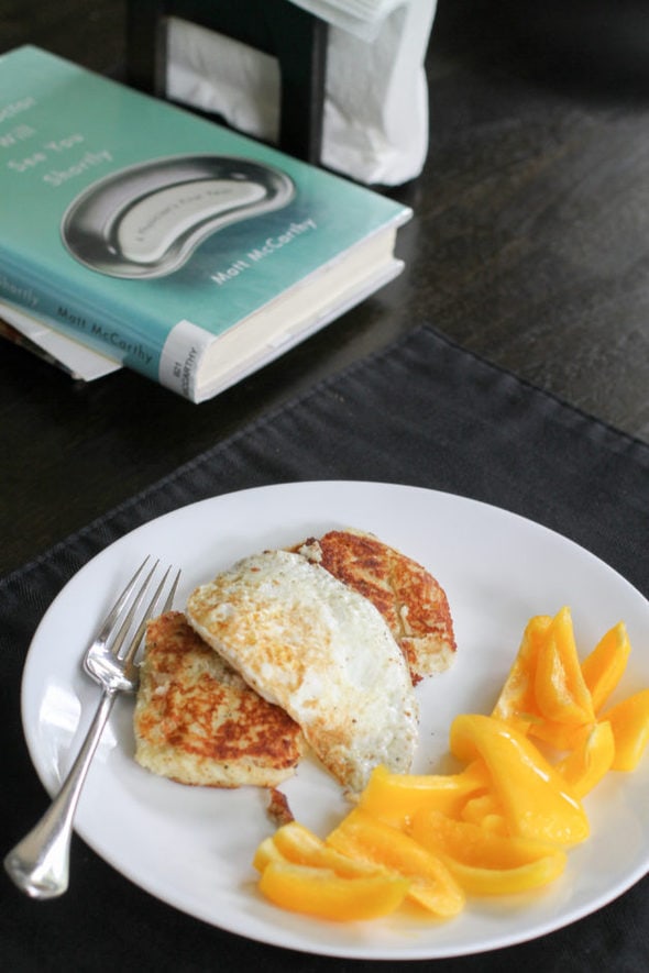 A white plate with potato cakes, fried egg, and yellow pepper slices.