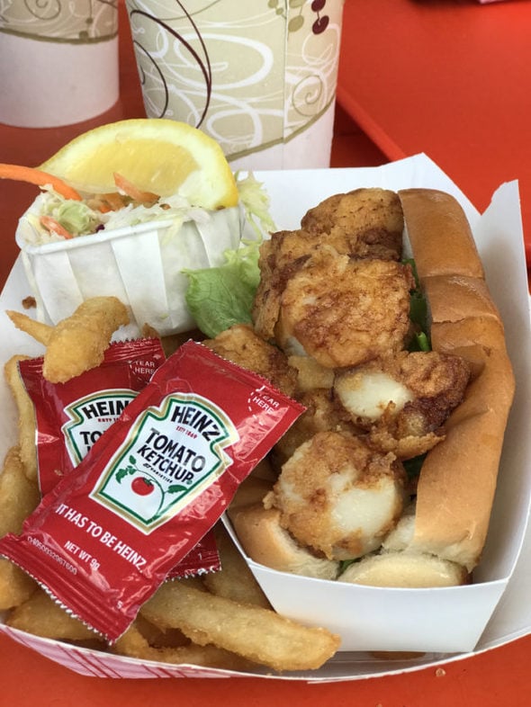 A scallop roll with fries and ketchup.