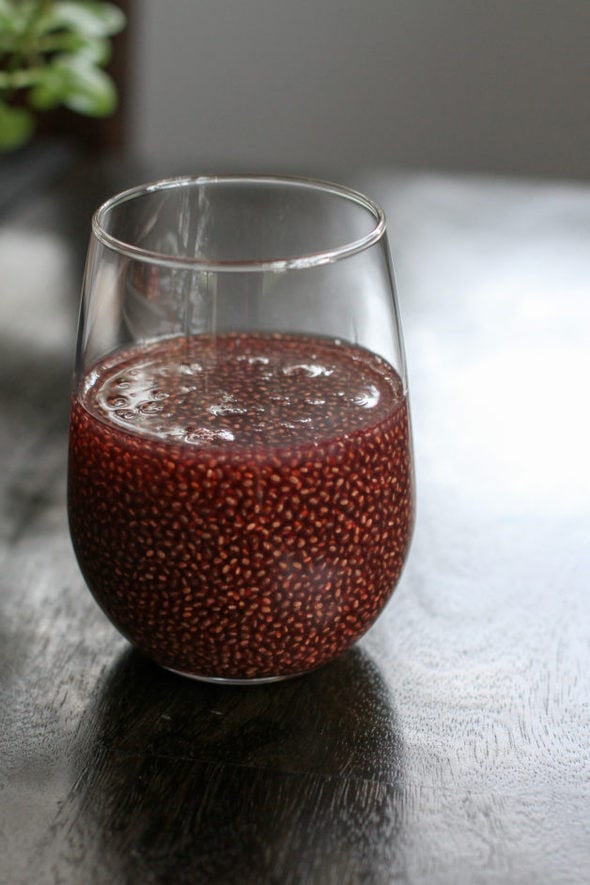 Red chia drink in a glass on a wood table.