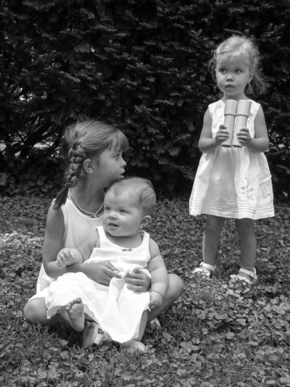 black and white of Lisey, Sonia, and Zoe in the grass.