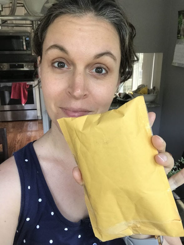 Kristen holding a small yellow padded envelope.