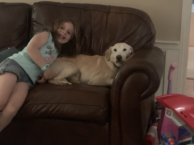 Barrie's daughter on the couch with their dog.