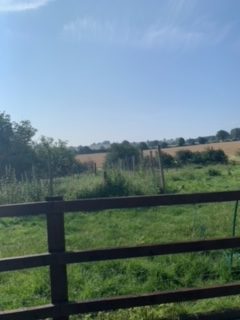 A farm fence under a blue sky.