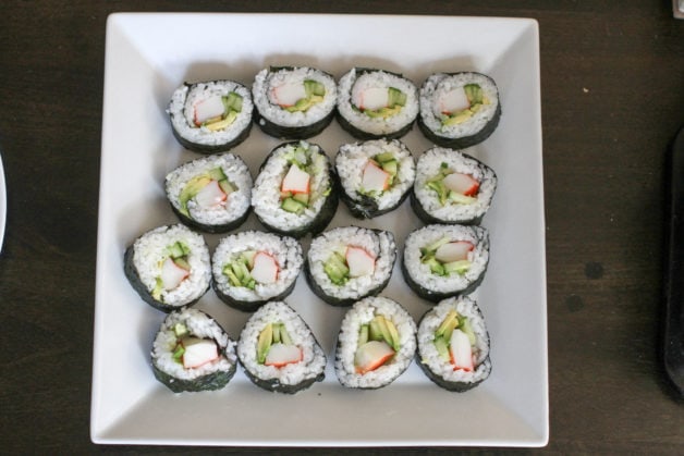 Homemade sushi on a square white plate.