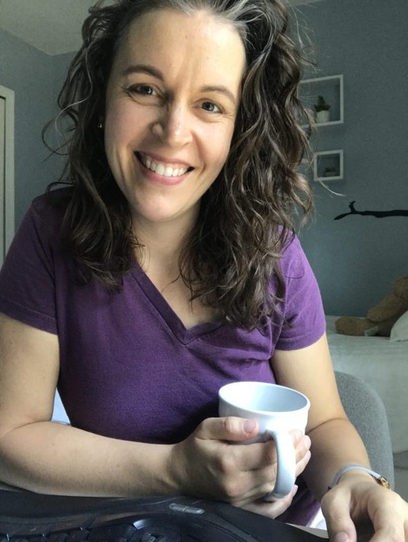 Kristen wearing a purple v-neck shirt, holding a white coffee mug.