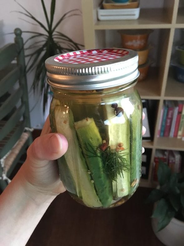 A glass jar of homemade pickles.