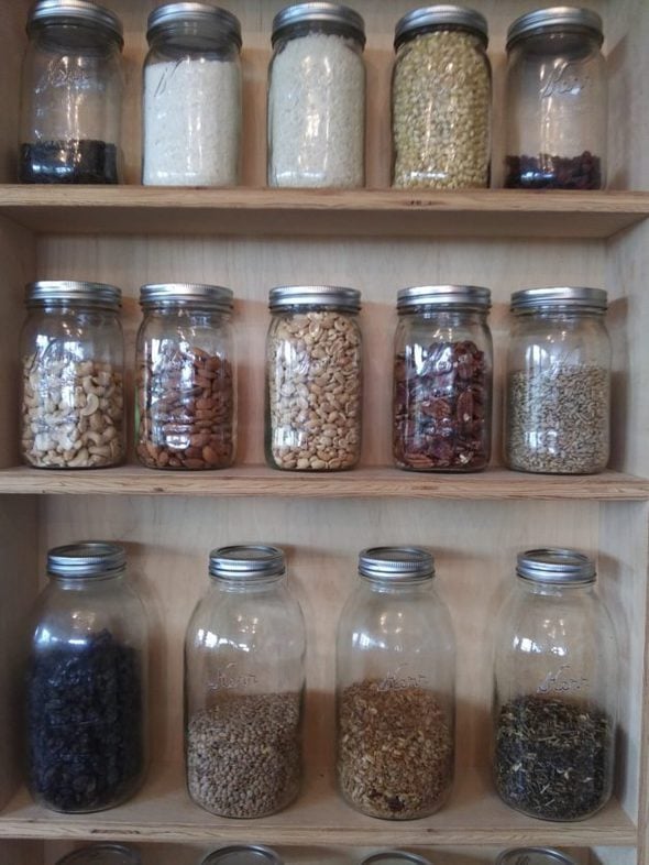 A pantry shelf full of glass jars.