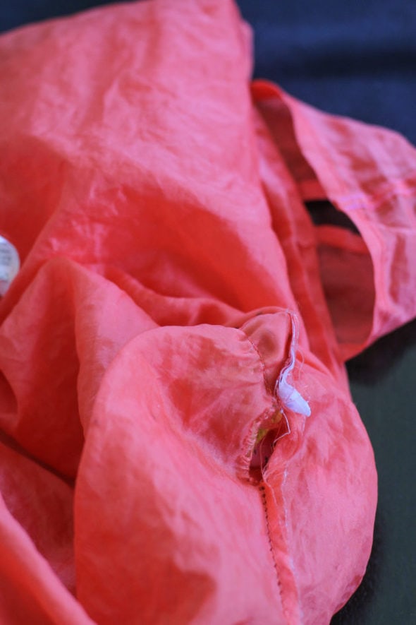 Coral bag with a hole in the seam.