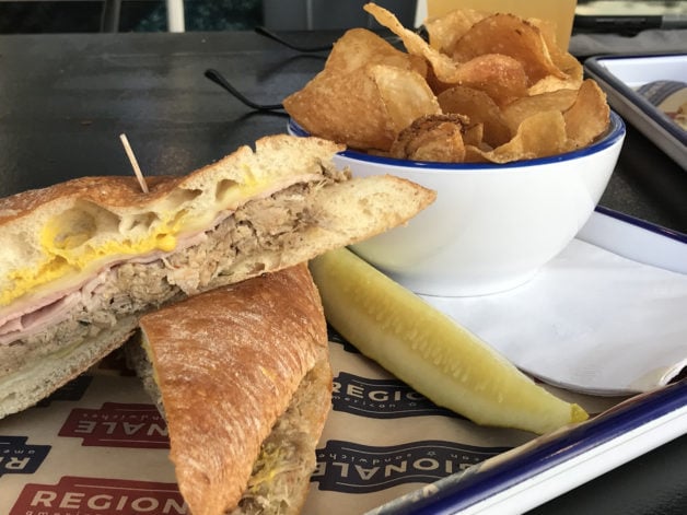 A cubano sandwich with chips.