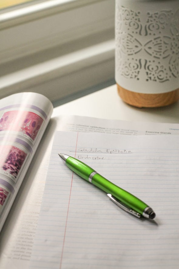 A green pen on a lined notebook page.