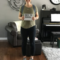 Kristen holding a back to school sign.