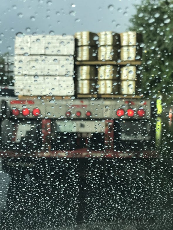 A view of a truck through a rainy windshield.