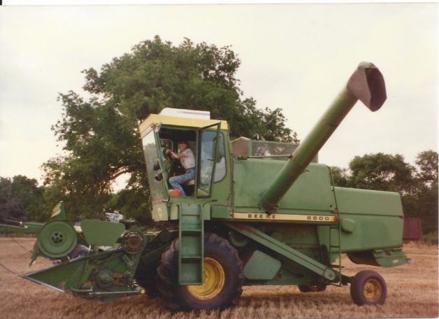Dorinda driving a green combine machine.