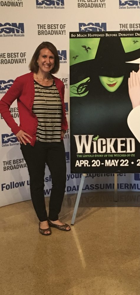 Rachel next to a Wicked musical poster.