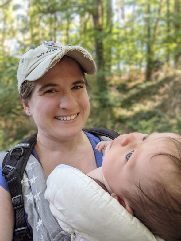 Beth with her baby in a carrier.