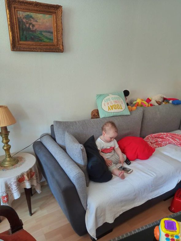 A little boy sitting on a couch.