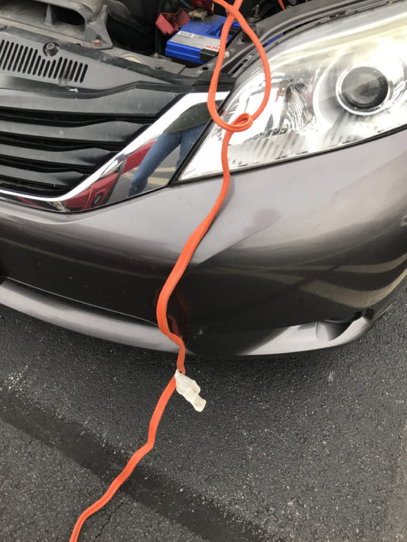 jumper cables on the front hood of a van.