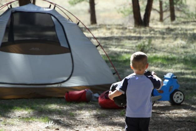 A little boy running toward a tent.