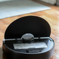 A Roborock vacuum with the lid up.