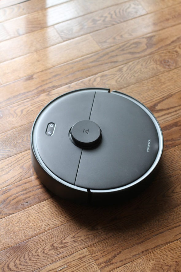 A roborock vacuum on a wooden floor.