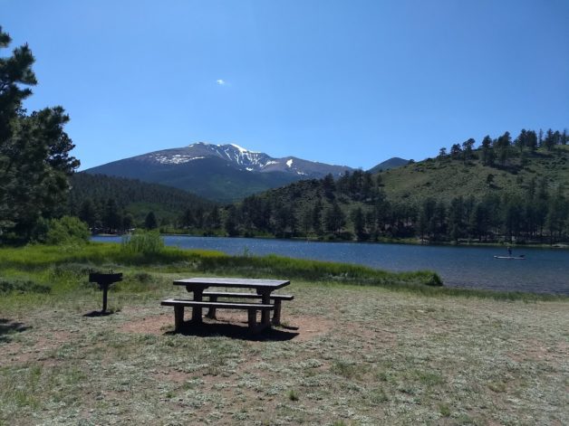 lake with a picnic bench in foreground.