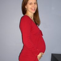 Kristen, pregnant, wearing a red shirt.