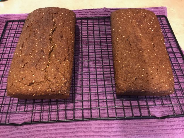 two loaves of bread on a cooling rack.