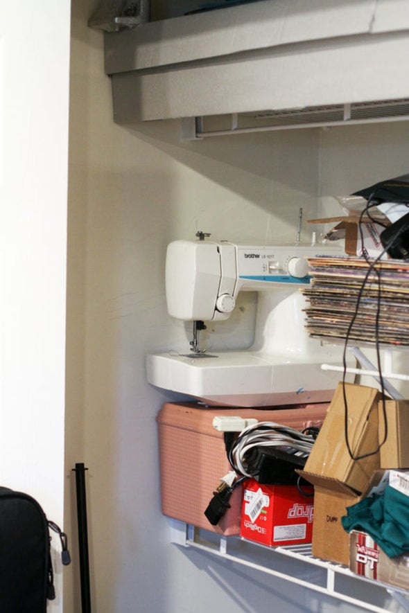 a white sewing machine on a closet shelf.