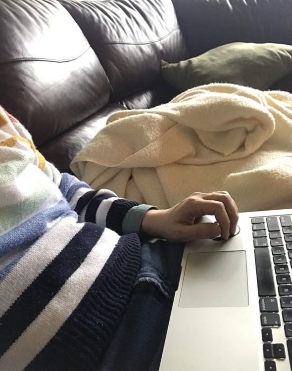 Kristen sitting on the couch with her laptop.