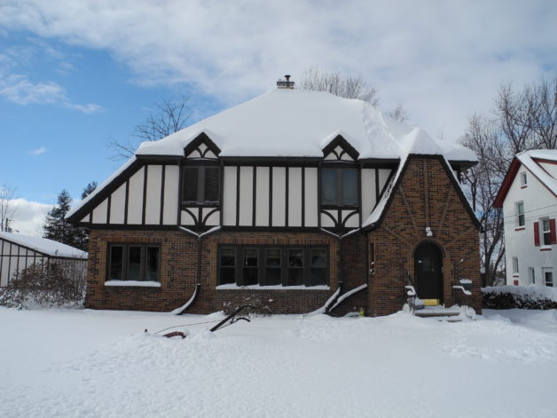 A house in the snow, under blue skies.