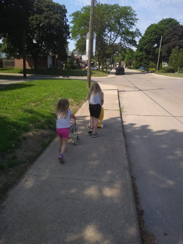 two girl running on a sidewalk.