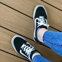 Kristen's feet in black vans sneakers.