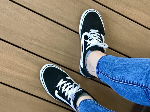 Kristen's feet in black vans sneakers.