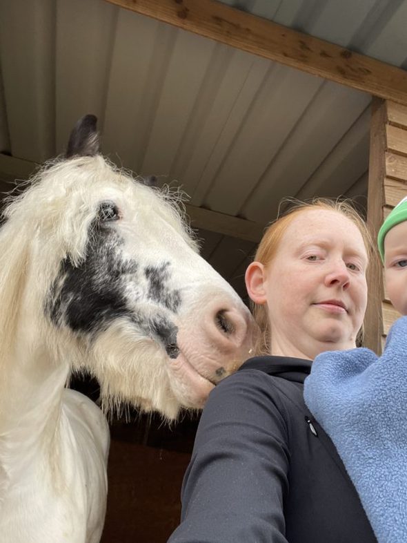 A woman with a horse and a baby.