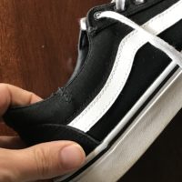 A mended black Vans shoe.