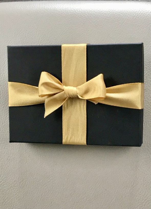 Black box tied with a gold ribbon.