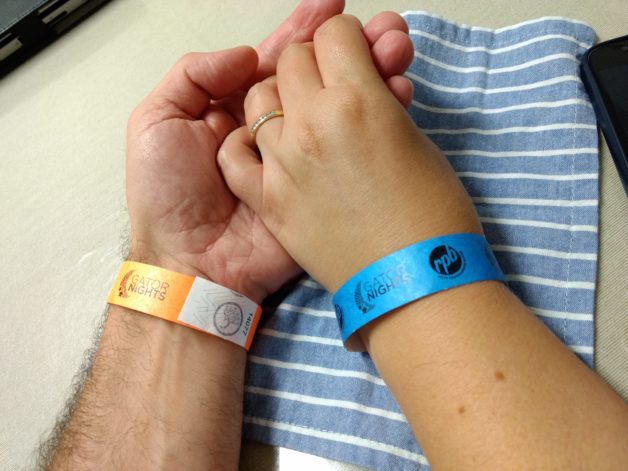 Two people's arms with wristbands.